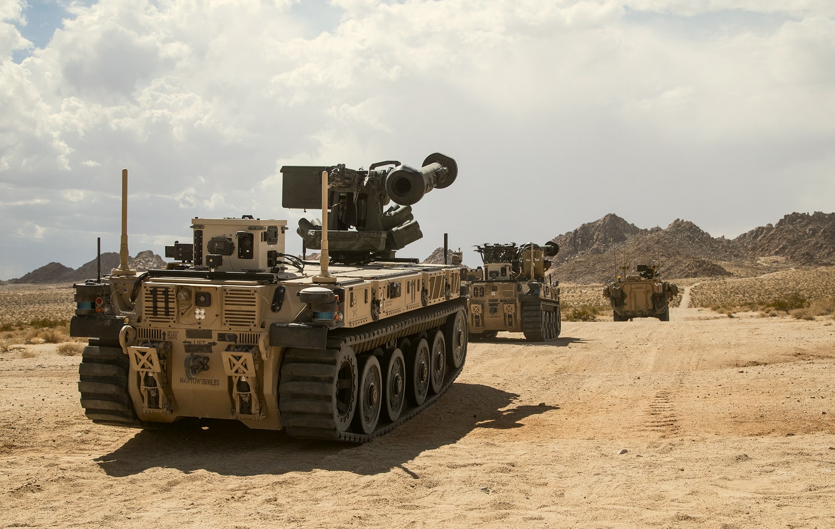 Image of vehicles in a convoy at a desert environment, providing defense.