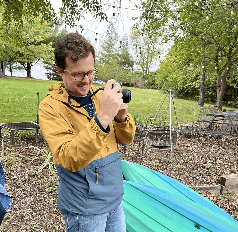 Team member photographing with a camera outdoors
