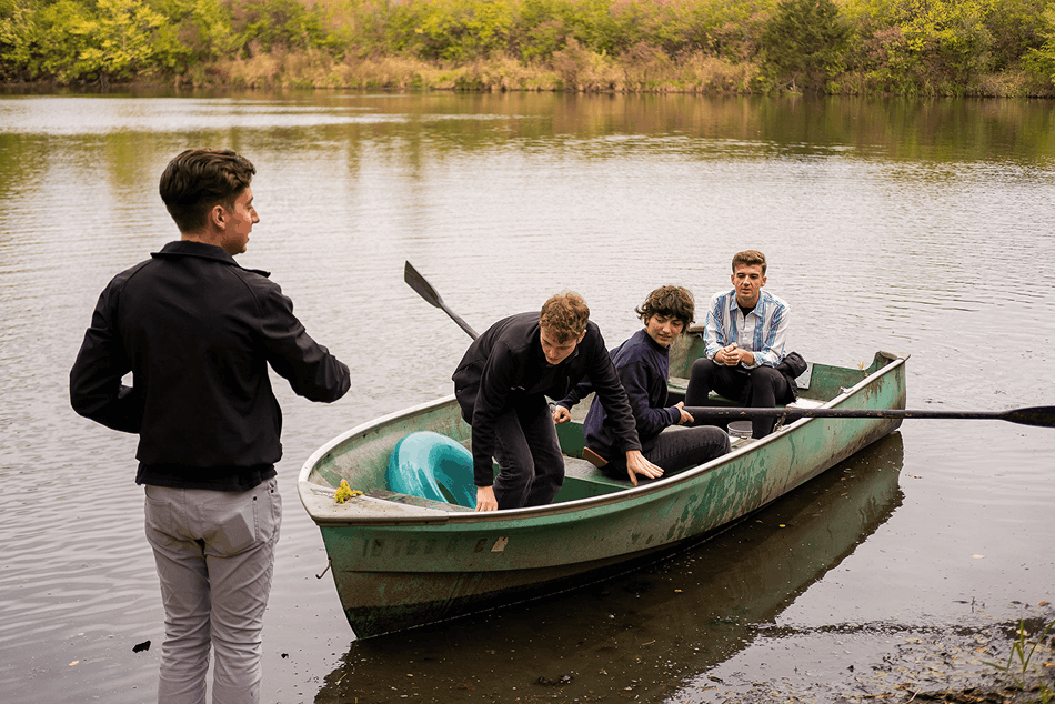Team gathered around a canoe by the water