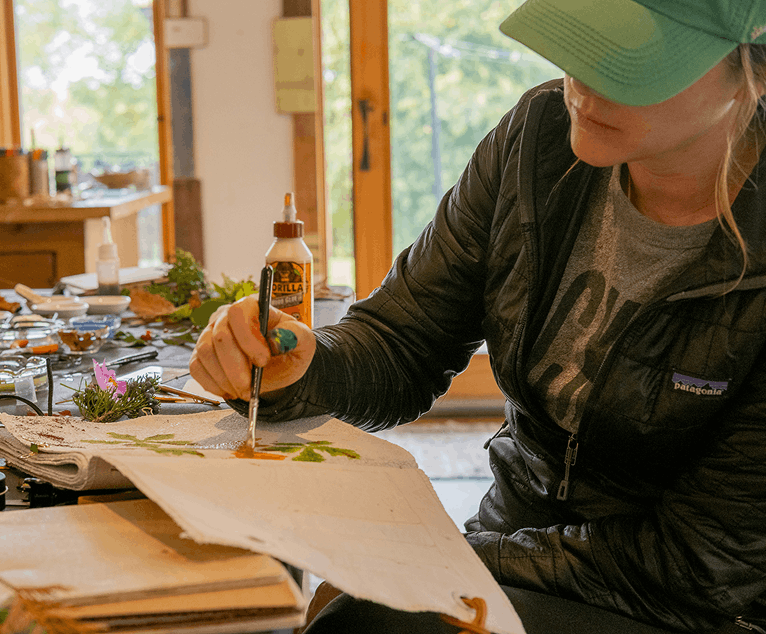 Team member working on a craft project by a window